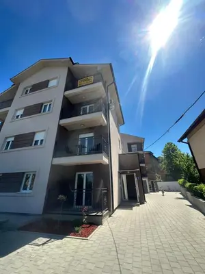 a tall building with the sun in the sky at Talija apartman 3 in Vrnjačka Banja