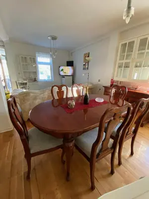 a wooden table and chairs in a living room at Vila Nada Apartment in Vrnjacka Banja in Vrnjačka Banja