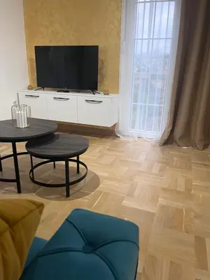 a living room with two tables and a tv at Apartman Daria in Vrnjačka Banja