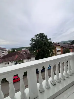 a white railing with blue umbrellas on a balcony at Apartman Daria in Vrnjačka Banja