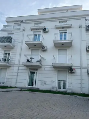 a white building with balconies on the side of it at Apartman Daria in Vrnjačka Banja