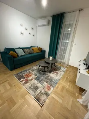 a living room with a green couch and a table at Apartman Daria in Vrnjačka Banja