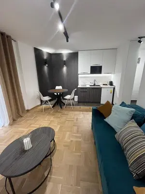 a living room with a blue couch and a table at Apartman Daria in Vrnjačka Banja