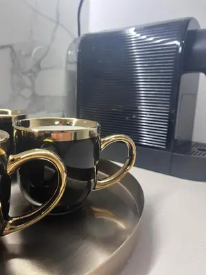 a gold coffee cup on a plate next to a microwave at Apartman Daria in Vrnjačka Banja