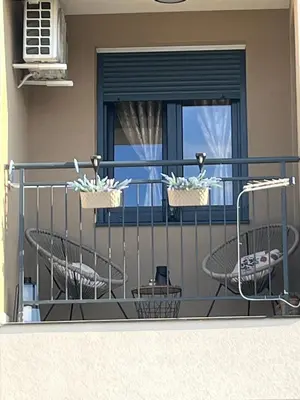 a balcony with two baskets of chairs and a window at Lenka Lux VB in Vrnjačka Banja