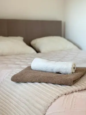 a rolled up towel sitting on top of a bed at Lenka Lux VB in Vrnjačka Banja