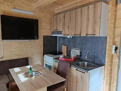 a kitchen with a table and a sink and a tv at Tosic etno kamp in Pirot
