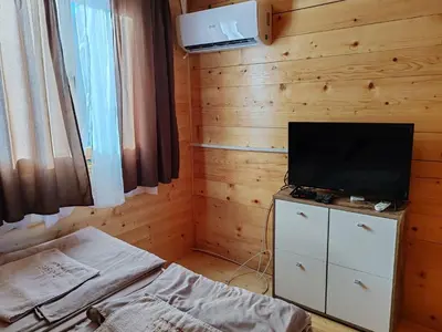 a bedroom with a television on a dresser with a bed at Tosic etno kamp in Pirot