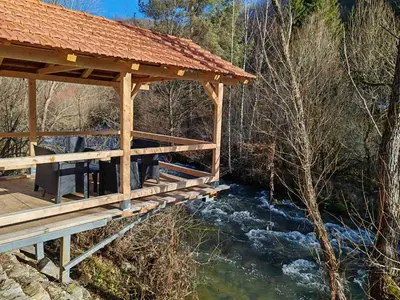 a wooden bridge over a river in a forest at Tosic etno kamp in Pirot