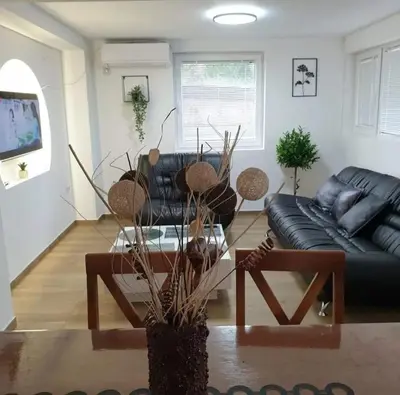 a living room with a black couch and a table at Apartman Djukic Sokobanja 1 in Soko Banja