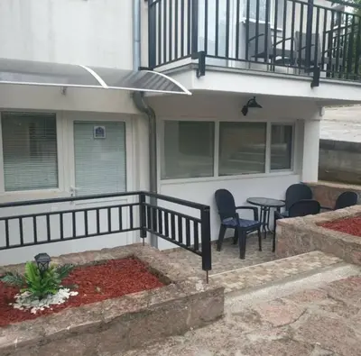 a porch of a house with chairs and a table at Apartman Djukic Sokobanja 1 in Soko Banja