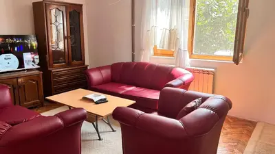a living room with a red couch and a table at Milovanović in Kuršumlija