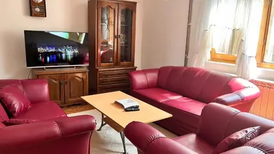 a living room with two red couches and a table at Milovanović in Kuršumlija