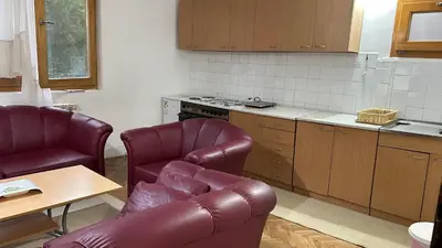 a kitchen with two leather chairs and a table at Milovanović in Kuršumlija