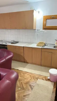 a kitchen with wooden cabinets and a counter top at Milovanović in Kuršumlija