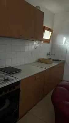 a kitchen with wooden cabinets and a sink and a stove at Milovanović in Kuršumlija