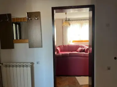a living room with a red couch and a window at Milovanović in Kuršumlija