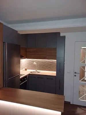 a kitchen with black cabinets and a stainless steel refrigerator at Mila apartman in Prokuplje
