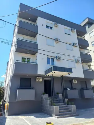 a white building with stairs in front of it at Aqua Apartments 1 in Jagodina