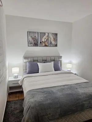 a bedroom with a large bed with blue pillows at Apartman WIN Sokobanja in Soko Banja