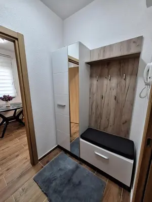 a room with a closet with a bench and a mirror at Apartman WIN Sokobanja in Soko Banja