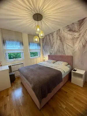 a bedroom with a large bed with a wall at Violet deluxe in Niš