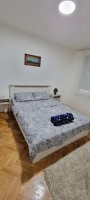 a bedroom with a bed in a room with a rug at Apartman Kraljevo-ceo stan,privatan parking in Kraljevo