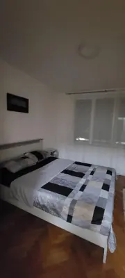 a bedroom with a bed with a black and white blanket at Apartman Kraljevo-ceo stan,privatan parking in Kraljevo