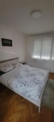 a bedroom with a bed with a white bedspread at Apartman Kraljevo-ceo stan,privatan parking in Kraljevo