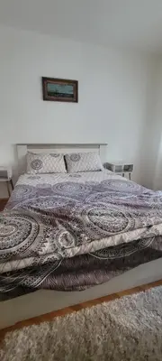 a bed in a bedroom with a blanket on it at Apartman Kraljevo-ceo stan,privatan parking in Kraljevo