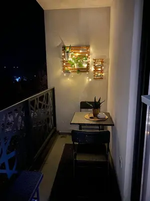a table and chairs on a balcony at night at Hakuna Matata 2 in Vrnjačka Banja