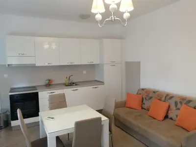 a living room with a couch and a table with orange pillows at Jagodina Wing Apartman 2 in Jagodina