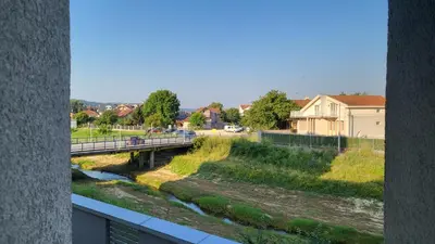 a bridge over a river with people walking on it at Jagodina Wing Apartman 2 in Jagodina