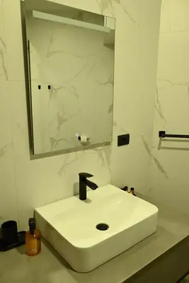 a bathroom with a white sink and a mirror at Paradiso in Leskovac