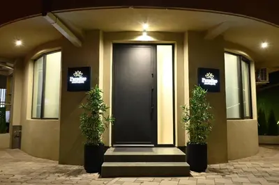 a front door of a building with two potted plants at Paradiso in Leskovac