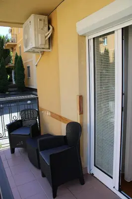 a balcony with two chairs and a heater at Apartman Lorenzo in Vrnjačka Banja