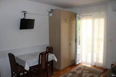 a dining room with a table and chairs and a sliding door at Apartman Lorenzo in Vrnjačka Banja