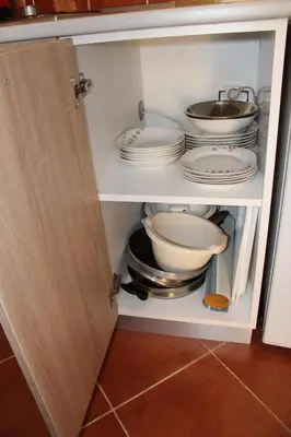 a cupboard filled with plates and bowls and pans at Apartman Lorenzo in Vrnjačka Banja