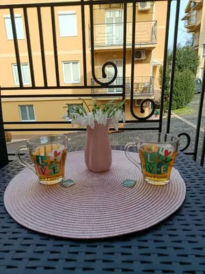 a table with two cups and a vase on it at Apartman Lorenzo in Vrnjačka Banja