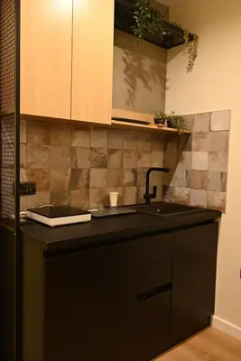 a kitchen with a sink and a black counter top at Paradiso 2 in Leskovac