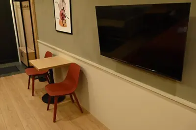 a small table with two chairs and a television on a wall at Paradiso 3 in Leskovac