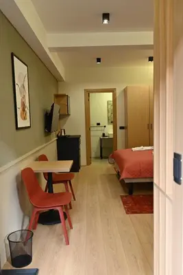 a room with a bed and a desk and a table at Paradiso 3 in Leskovac