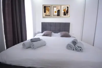 a bedroom with a white bed with towels on it at Vila-L&M- Royal in Lipova