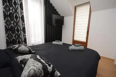 a bedroom with a black bed with two towels on it at Vila-L&M- Royal in Lipova