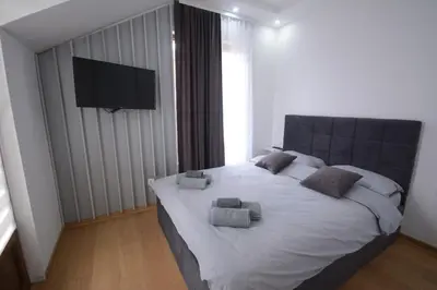 a bedroom with a large bed with a flat screen tv at Vila-L&M- Royal in Lipova