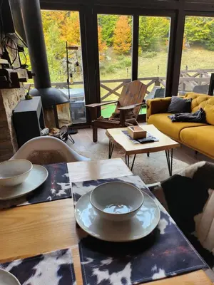 a living room with a table and a yellow couch at Ski & Spa Bungalows in Kopaonik