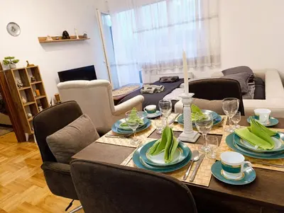 a dining room table with plates and wine glasses at Apartman Elizabet in Pirot
