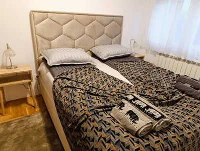 a bed with a cheetah blanket and pillows on it at Apartman Elizabet in Pirot