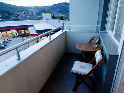 a balcony with a table and a chair and a window at Apartman Elizabet in Pirot