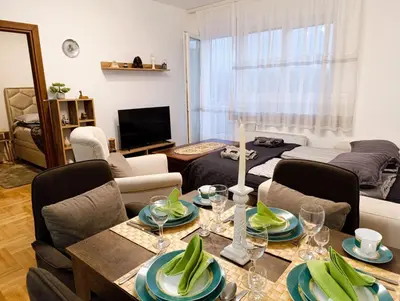 a living room with a table and chairs and a couch at Apartman Elizabet in Pirot